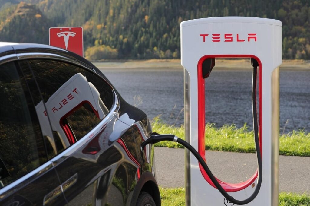 carro da Tesla tendo a sua bateria recarregada no eletroposto